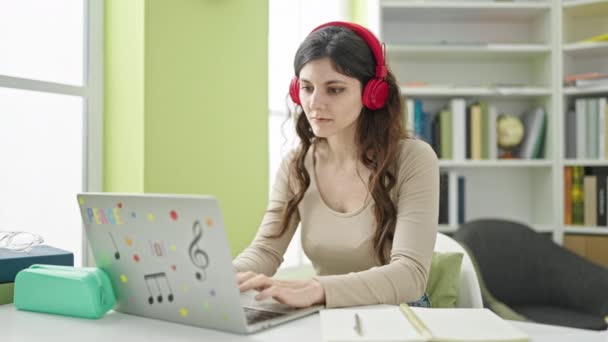 Kütüphanede Dizüstü Bilgisayar Kulaklık Kullanan Güzel Spanyol Bir Kız Öğrenci — Stok video