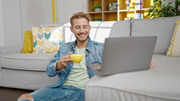 若い白人男性は自宅でコーヒーを飲むビデオコールを持っています — ストック動画