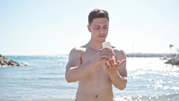 Молодий Іспаномовний Чоловік Турист Стоїть Розслабленим Виразом Застосування Сонцезахисного Крему — стокове відео