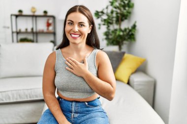 Genç ve güzel İspanyol kadın evdeki kanepede oturan sağırlarla iletişim kuruyor.