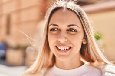 Sokakta kendinden emin gülümseyen genç bir kadın