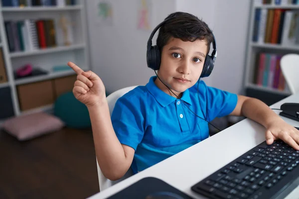 在学校里 他的恐慌小男孩在用电脑笔记本电脑开心地微笑着 手指手画脚地指向旁边 — 图库照片
