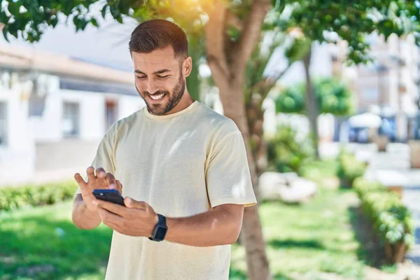 Jonge Spaanse Man Glimlacht Vol Vertrouwen Met Smartphone Het Park — Stockfoto
