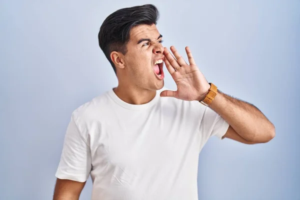 Hispanic Man Standing Blue Background Shouting Screaming Loud Side Hand — Stockfoto