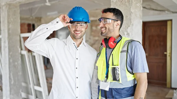建設現場で二人の男の建築家と建築家が共に笑顔で立っている — ストック写真