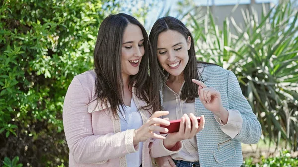 Två Kvinnor Ler Tryggt Med Smartphone Parken — Stockfoto