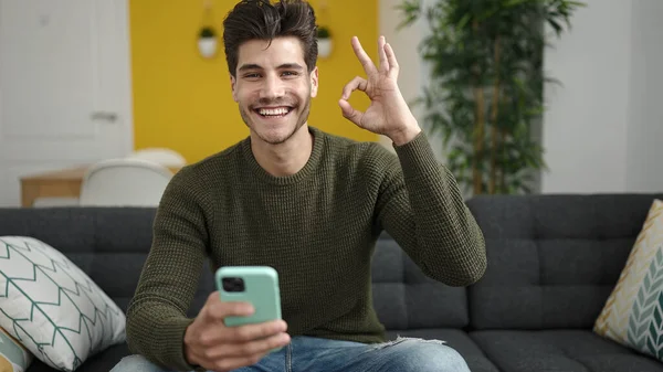 Young Hispanic Man Using Smartphone Doing Gesture Home — 스톡 사진