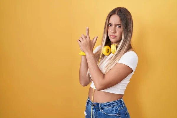 Junge Blonde Frau Steht Über Gelbem Hintergrund Und Trägt Kopfhörer — Stockfoto