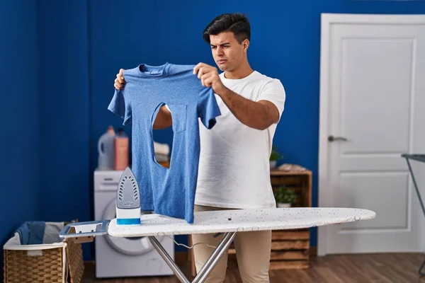 Homem Hispânico Engomando Segurando Camisa Ferro Queimado Lavanderia Cético Nervoso — Fotografia de Stock