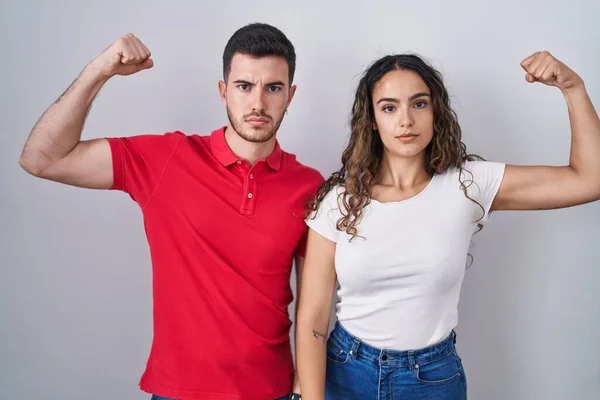 Young Hispanic Couple Standing Isolated Background Strong Person Showing Arm — Stock Photo, Image