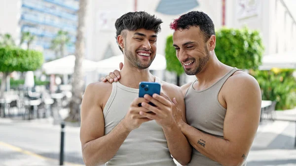 两个男人在咖啡店的阳台上 用智能手机自信地微笑着 — 图库照片