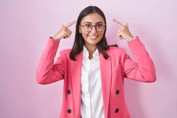 若いヒスパニック系の女性は ビジネス服や眼鏡を両手の指で頭を指して笑顔 素晴らしいアイデアや考え 良い記憶 — ストック写真