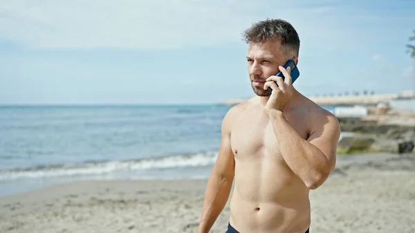 ビーチでスマートフォンで話している若い男の観光客 — ストック写真