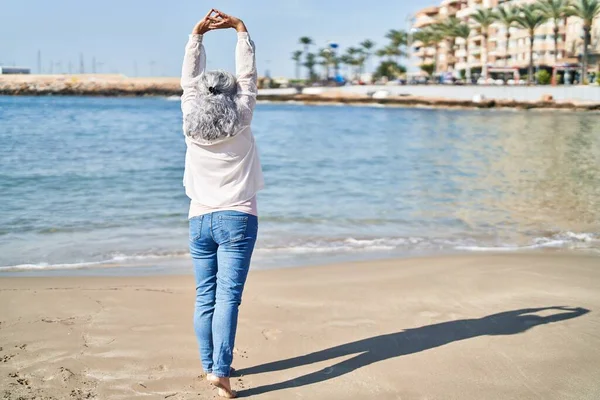中年妇女在海滨张开双臂 — 图库照片