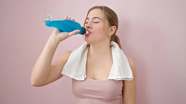 Młoda Blondynka Ubrana Strój Sportowy Pijąca Energetyczny Napój Odizolowanym Różowym — Zdjęcie stockowe