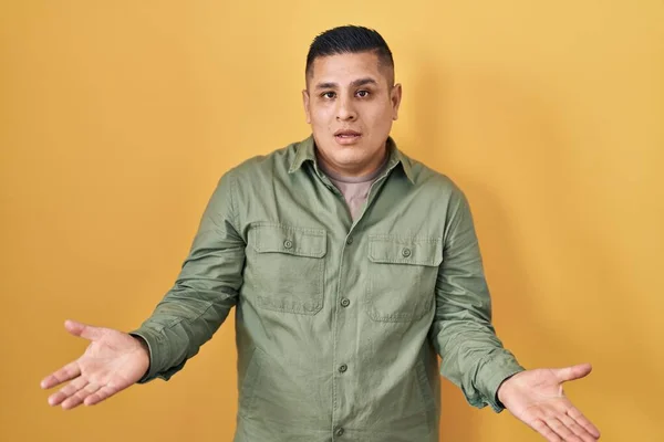 Hispanic Young Man Standing Yellow Background Clueless Confused Open Arms — Stock Photo, Image