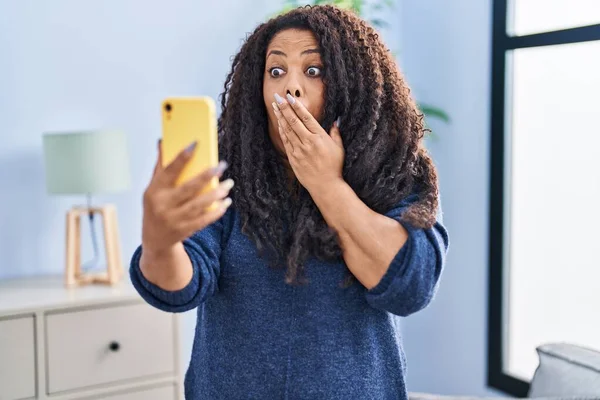 プラスサイズのパニック女性は手で口をカバースマートフォンでビデオ通話を行う ショックを受け 間違いを恐れています 驚きの表情 — ストック写真
