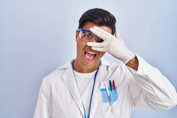 Homem Hispânico Trabalhando Como Cientista Espreitando Choque Cobrindo Rosto Olhos — Fotografia de Stock