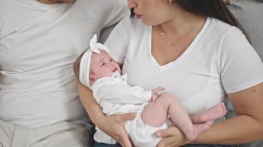 Üç kişilik aile evdeki kanepede oturuyor.