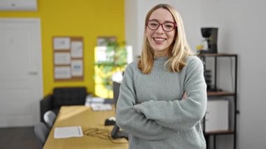 Genç sarışın iş kadını ofiste kendine güvenen gülümseyen