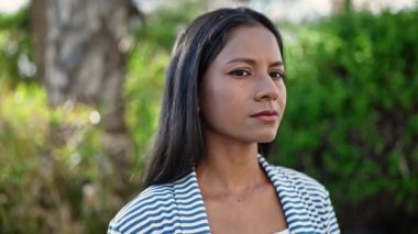 African american woman standing with serious expression at park