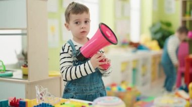 Anaokulunda elinde megafonla bekleyen sevimli çocuklar.