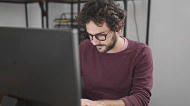 Young hispanic man business worker using computer working at office