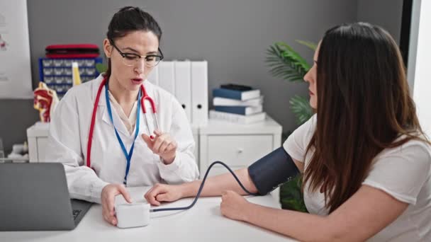 Två Kvinnliga Läkare Och Patient Mäter Pulsen Med Tensiometer Kliniken — Stockvideo