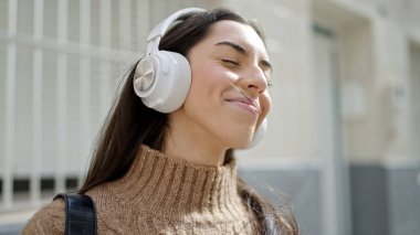 Genç, güzel, İspanyol bir kadın. Kendine güvenen, sokakta müzik dinleyen.