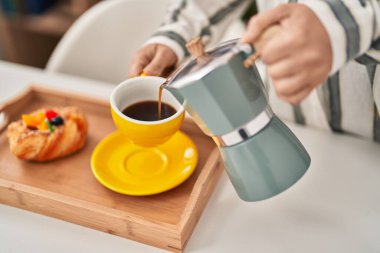 Genç Çinli kadın kahvaltısını evde yapıyor.