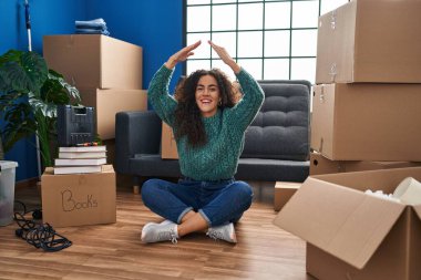 Genç İspanyol kadın yeni evinde yerde oturuyor ve kahkahalarla gülüyor çünkü komik, çılgınca bir şaka.. 