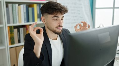 Genç Arap erkek öğrenci üniversite sınıfında yoga egzersizi yapıyor.