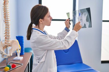 Rehabilitasyon kliniğinde ciddi yüzü olan genç sarışın fizyoterapist.