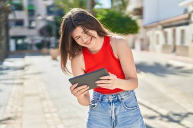 Young caucasian woman smiling confident watching video on touchpad at park