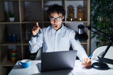 Geceleri ofiste çalışan İspanyol bir adam parmaklarını göstererek reklamını yapıyor, şaşırmış bir yüz ve ağzını açıyor. 