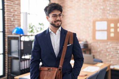 Young hispanic man business worker smiling confident standing at office