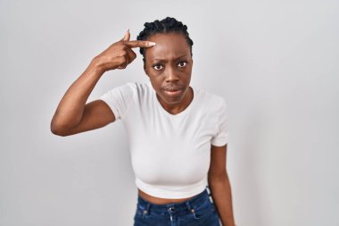 Güzel siyah kadın izole edilmiş arka planda duruyor. Alnındaki sivilceden mutsuz olduğunu gösteriyor. Siyah nokta enfeksiyonu. sivilce ve deri problemi 