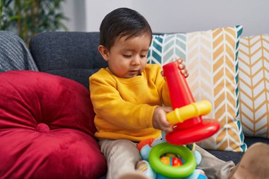 Evdeki kanepede oturan sevimli İspanyol çocuk basketbol oynuyor.