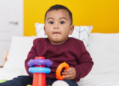 Sevimli İspanyol çocuk yatak odasında oturmuş basketbol oynuyor.
