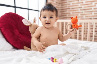 Sevimli İspanyol çocuk yatakta kendinden emin bir şekilde oturuyor.