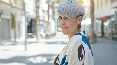 Young woman standing with serious expression at street