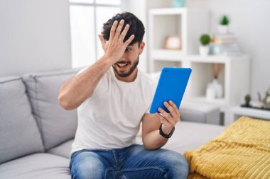 Kanepede oturan dokunmatik pedini kullanan sakallı İspanyol bir adam hata yaptığı için şaşırdı. Hatayı hatırla. Unuttum, kötü hafıza kavramı. 