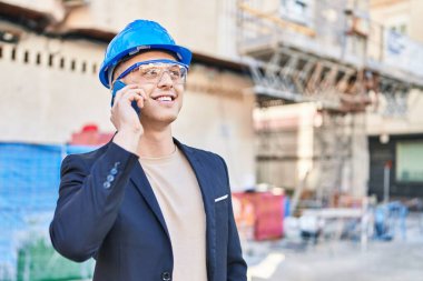 Genç İspanyol mimar gülümsüyor. Akıllı telefondan konuşuyor.