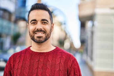 Sokakta kendinden emin gülümseyen İspanyol genç adam.