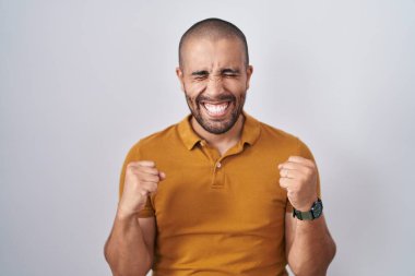 Beyaz arka planda duran İspanyol sakallı adam kolları havada ve gözleri kapalı zaferi kutlarken heyecanla bekliyor. Kazanan konsept. 