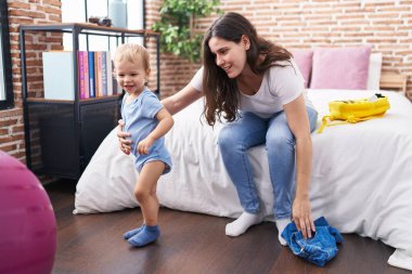 Anne ve oğlu yataklarında oturmuş, çocukları hazırlıyorlar.