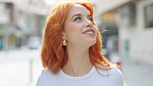 年轻的红头发女人面带微笑 自信地看着街上的天空 — 图库照片