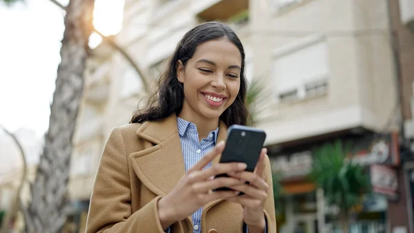 Νεαρή Όμορφη Ισπανόφωνη Γυναίκα Που Χρησιμοποιεί Smartphone Χαμογελώντας Στο Δρόμο — Φωτογραφία Αρχείου