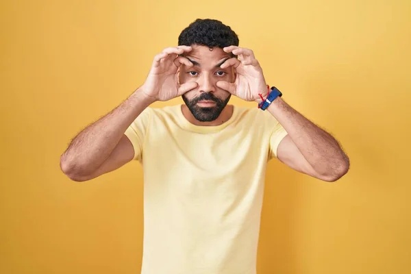 Homem Hispânico Com Barba Sobre Fundo Amarelo Tentando Abrir Olhos — Fotografia de Stock