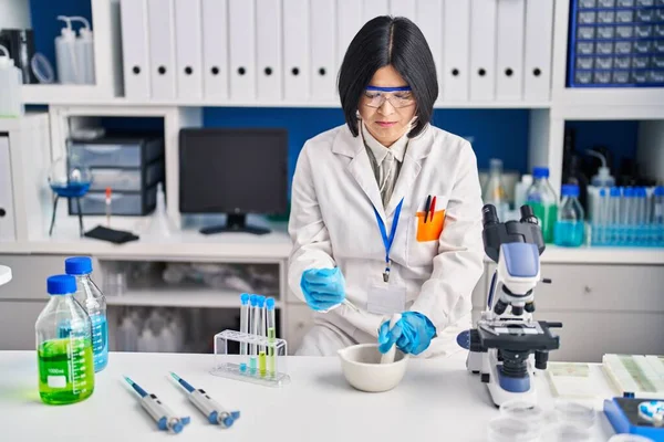 Young chinese woman scientist working at laboratory